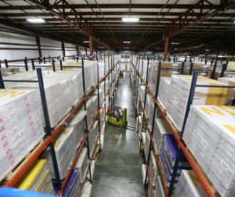 Warehouse racking with product and a forklift driver